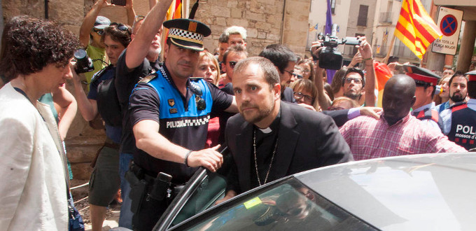 El obispo de Solsona sale de una iglesia escoltado por la polica entre gritos del lobby LGTBI